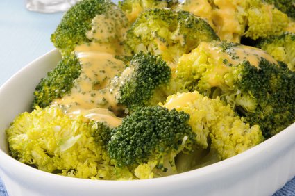 Steamed broccoli with cheddar cheese on top.