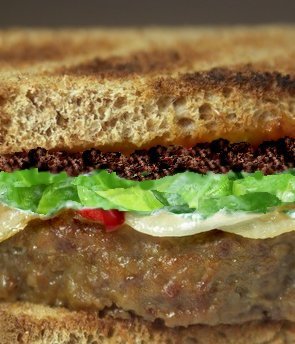 Italian meatloaf sandwich with tapenade and fresh spinach.